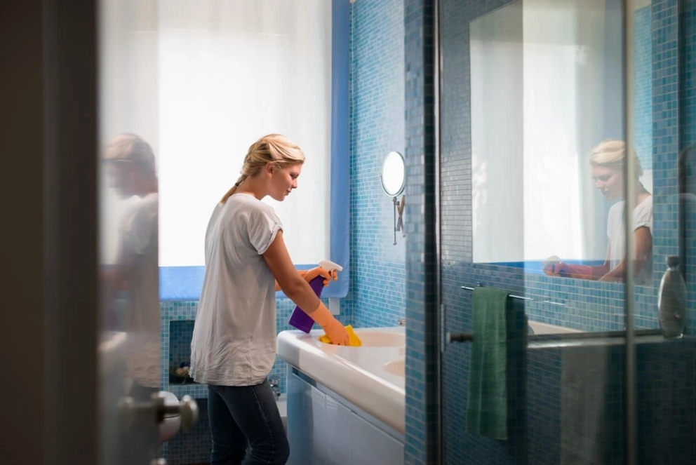 woman cleaning the bathroom sink