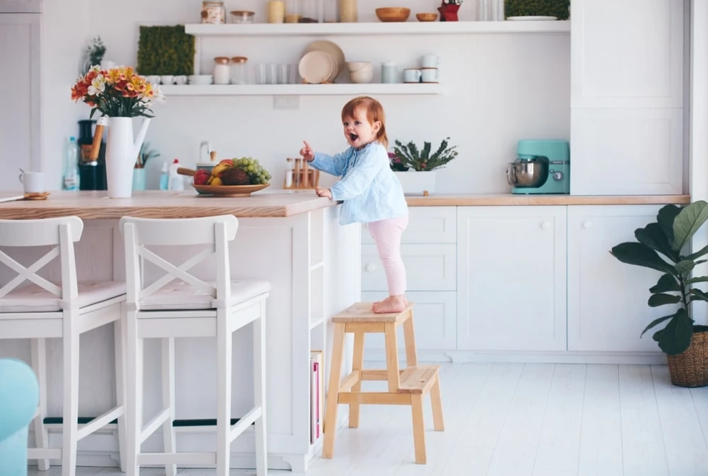 little baby staying on the step stool in the kitchen