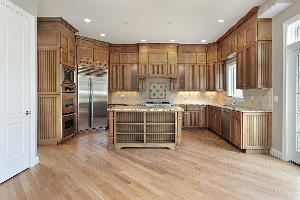 fluted wood kitchen cabinet set with an island and stainless steel appliances