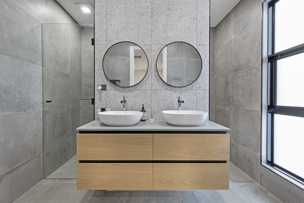 Modern ensuite bathroom with a shower, a wooden sink cabinet, and two mirrors