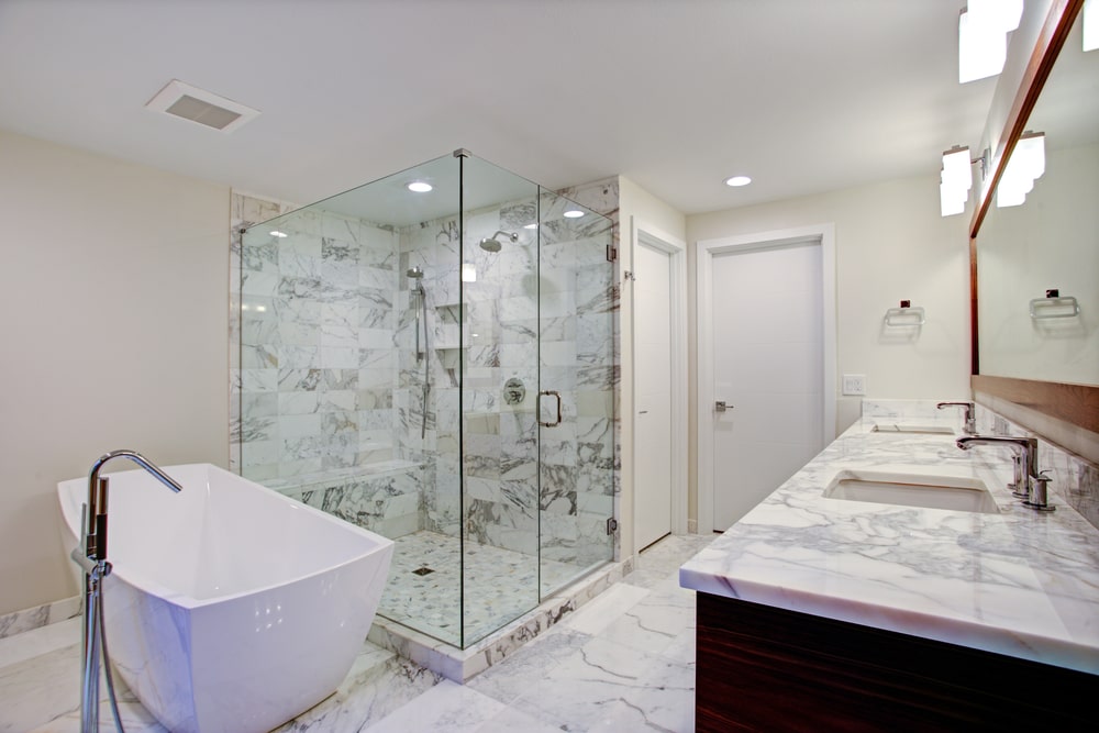 a costly bathroom with a freestanding tub, shower and high-end vanity with marble counter