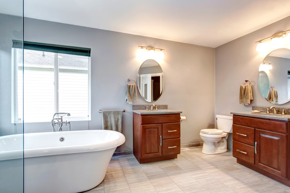 bathroom vanities with drawers and doors and bathtub in the spacious room