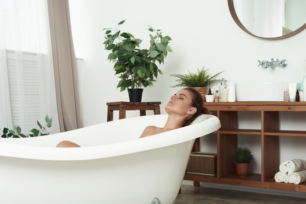 woman relaxing in a spa-like bathroom