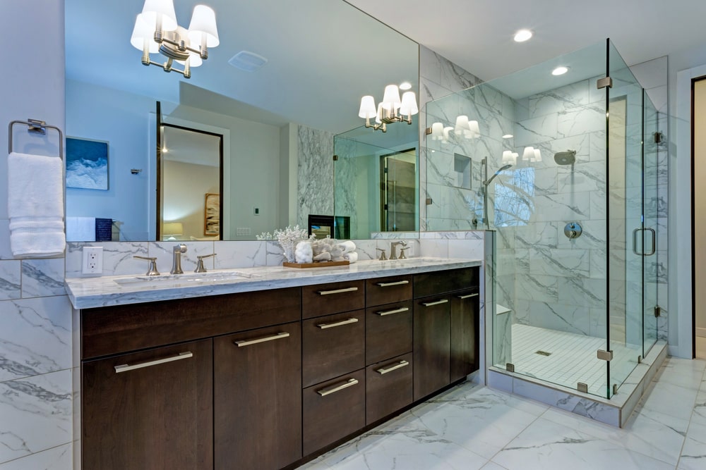 wooden custom vanity with marble counter and marble tiles in the bathroom