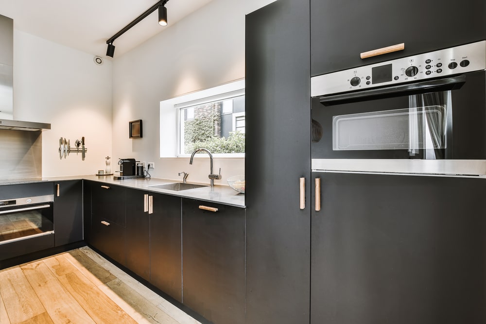 black matte cabinets and appliances in the modern condo kitchen