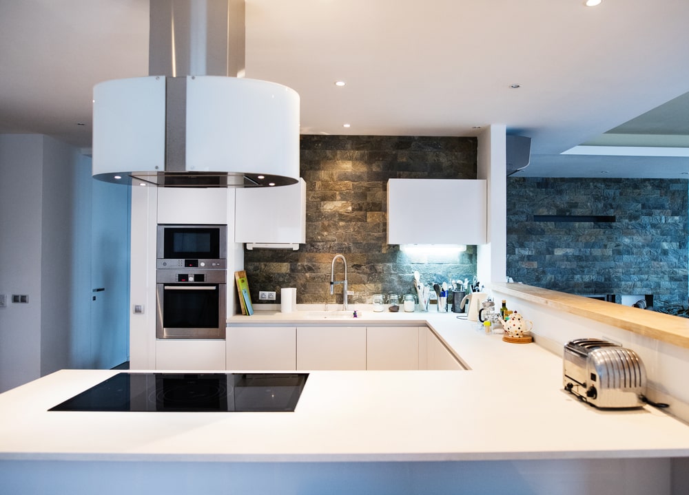 white kitchen with smart appliances and hood