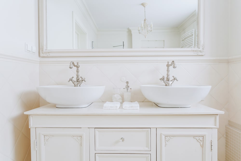 white painted bathroom double vanity with mirror
