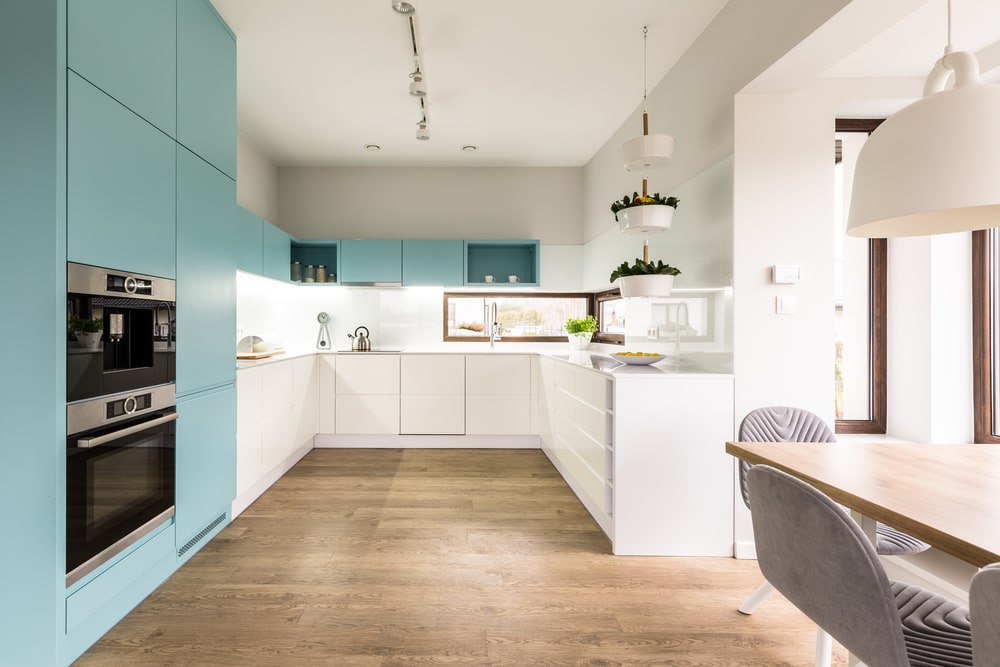 flat panel teal cabinets and stainless steel appliances in the white kitchen