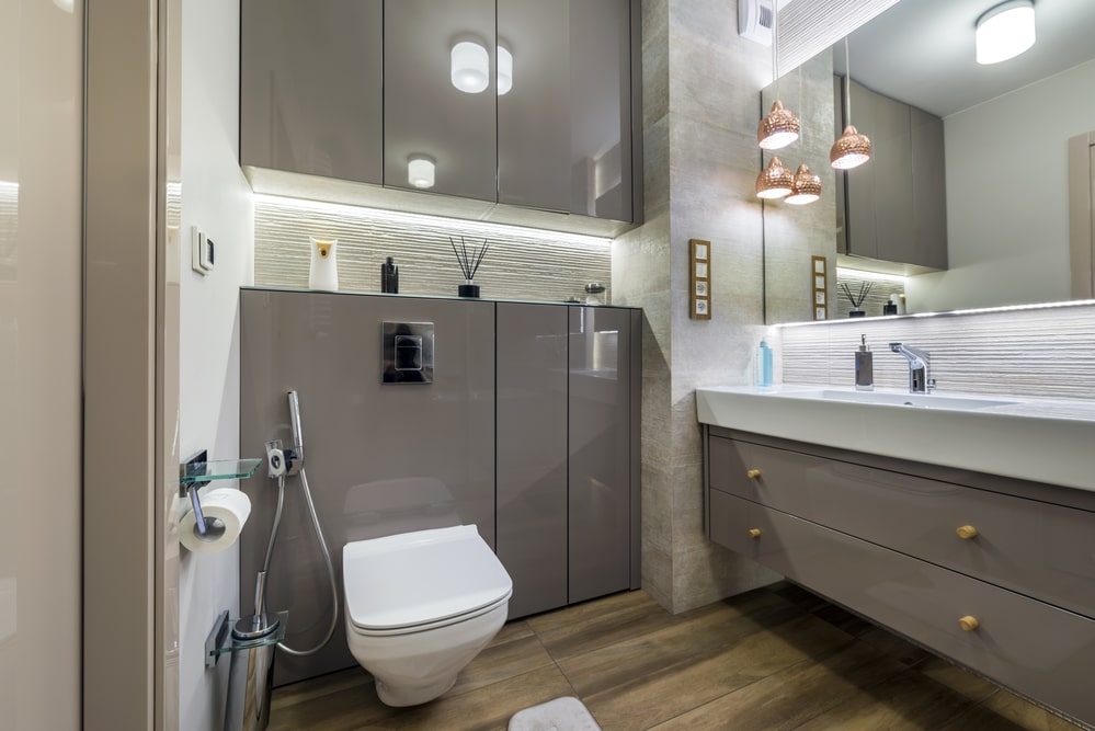 Grey wall hanging bathroom vanity and built-ins behind a toilet