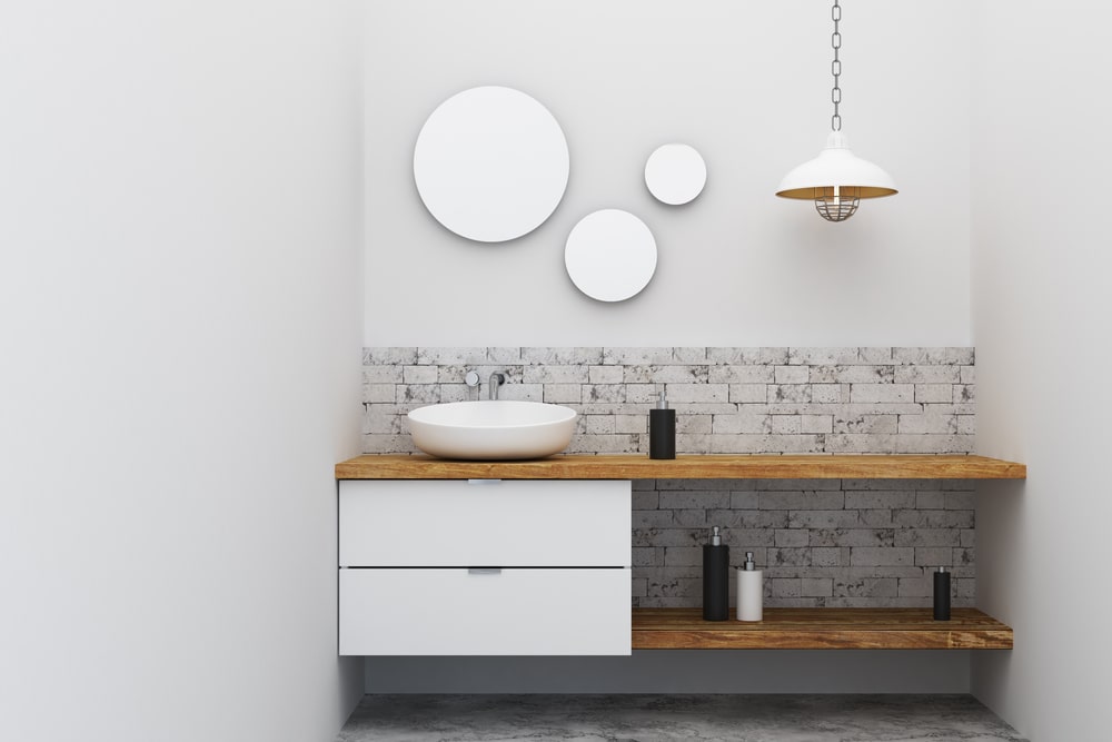 Industrial-style bathroom vanity with brick veneer backsplash