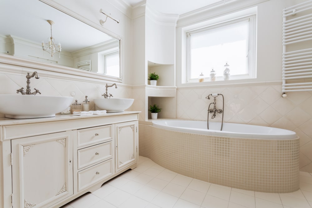 all-white bathroom with beaded vanity drawers and cabinets
