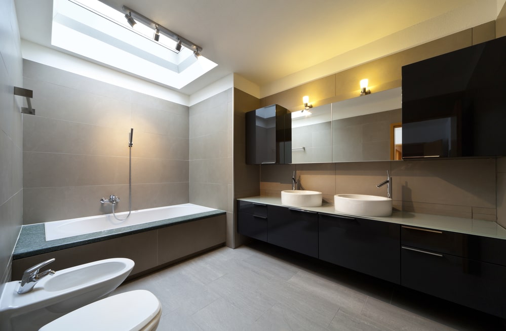 large bathroom with bathtub, black vanity and mirror cabinet