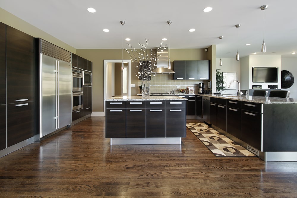large open space kitchen with black modern cabinets and steel aplianses