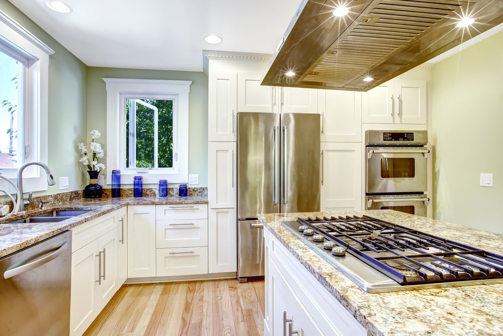 narrow cabinets surrounding the fridge - white kitchen with steel appliance