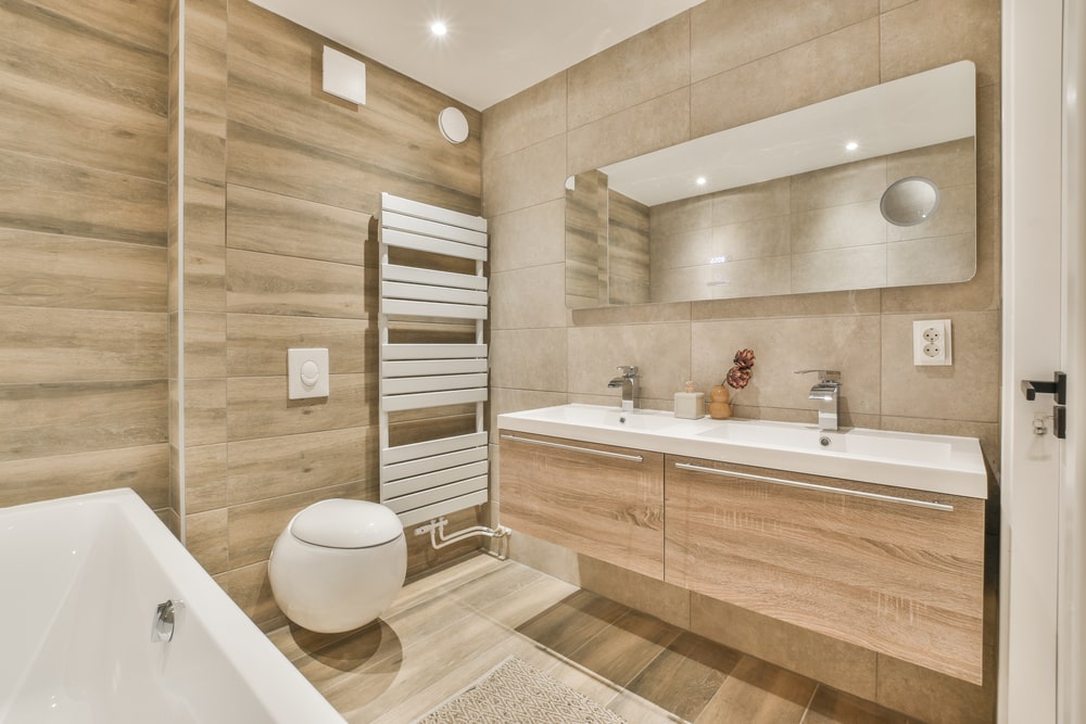 warm tones bathroom with wall hanging, vanity toilet and mirror