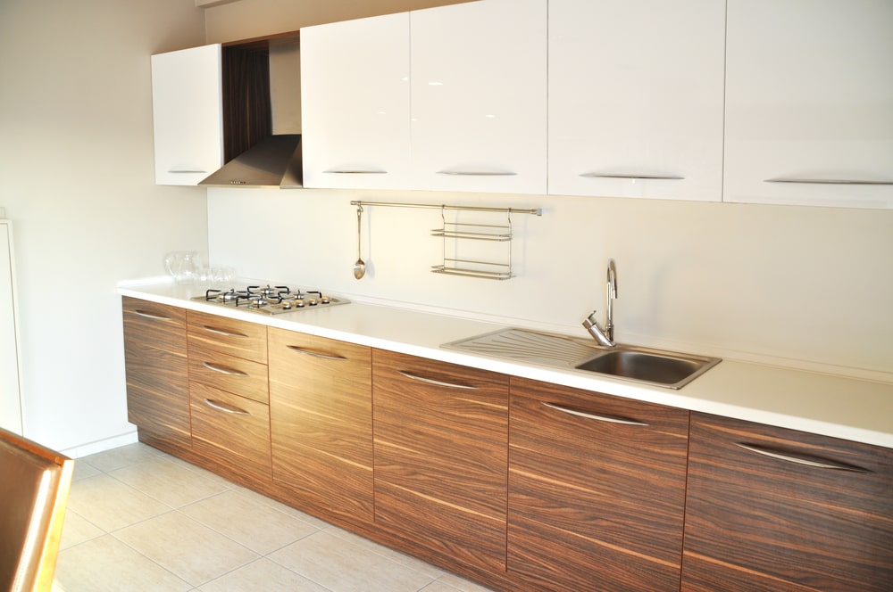 brand new kitchen with glossy white and wood veneer cabinets