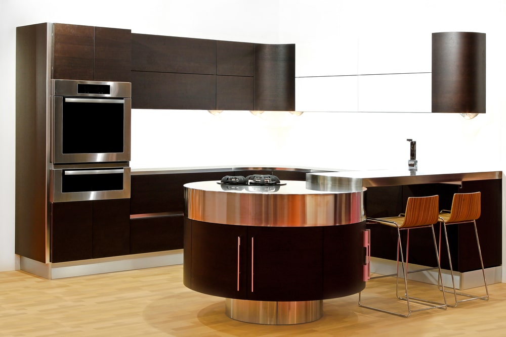 kitchen island with a rounded cabinet base and steel counter in the modern kitchen