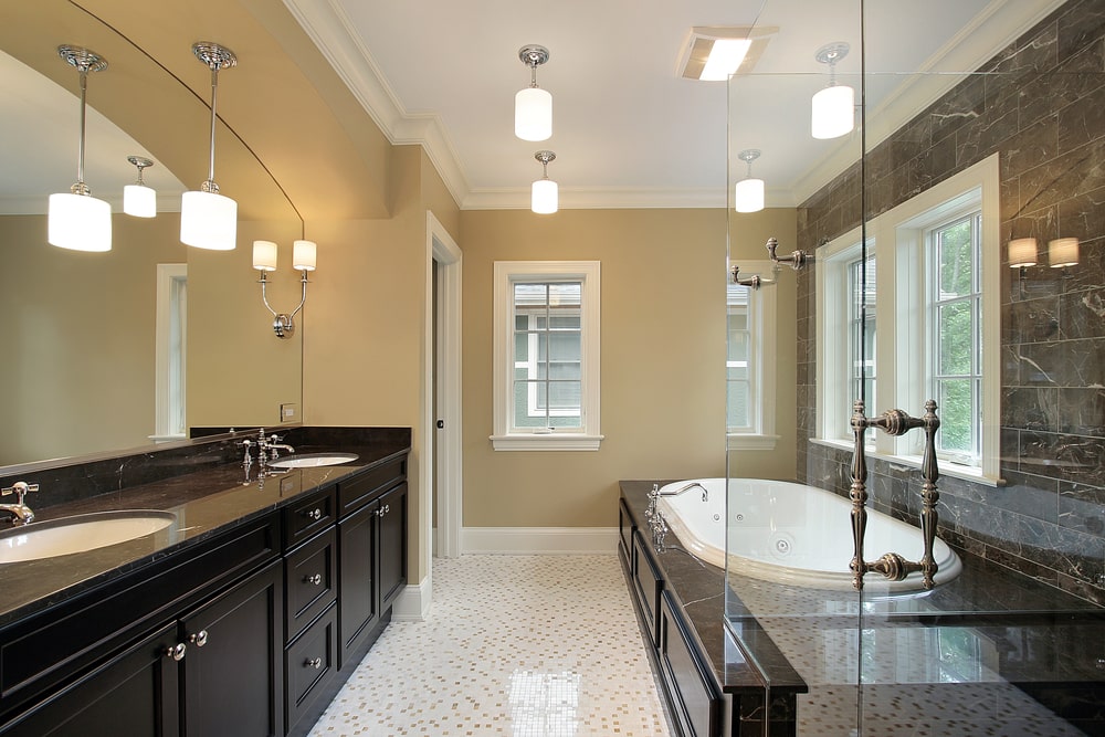 luxury bathroom with black shaker vanity and black marble counters