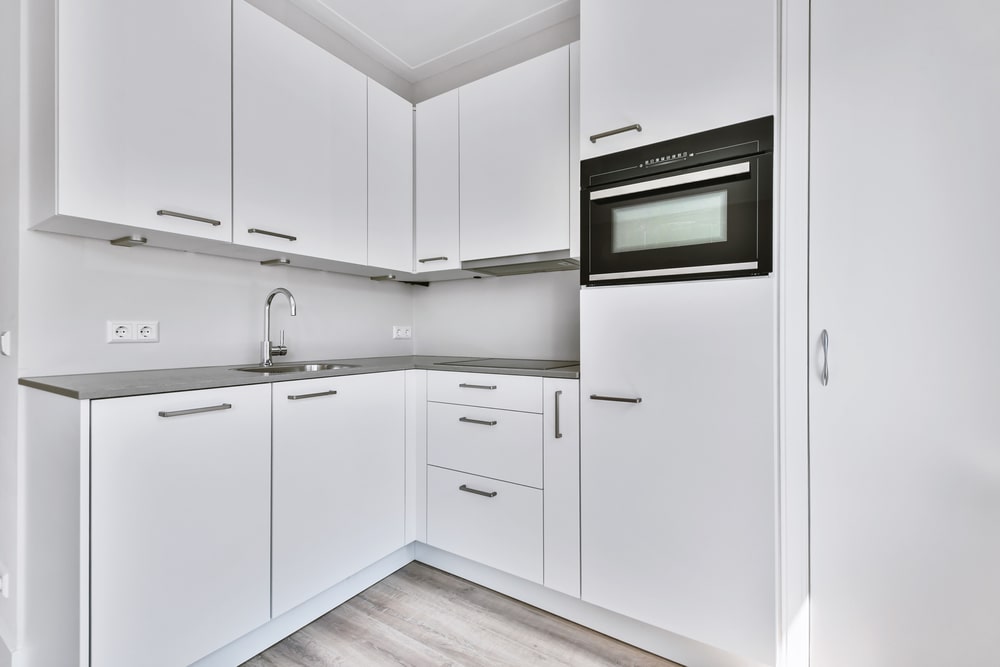 small l-shaped kitchen with tall cabinet white
