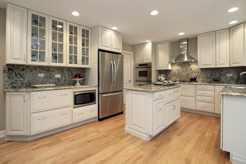 white kitchen with wall bridge cabinets above appliances
