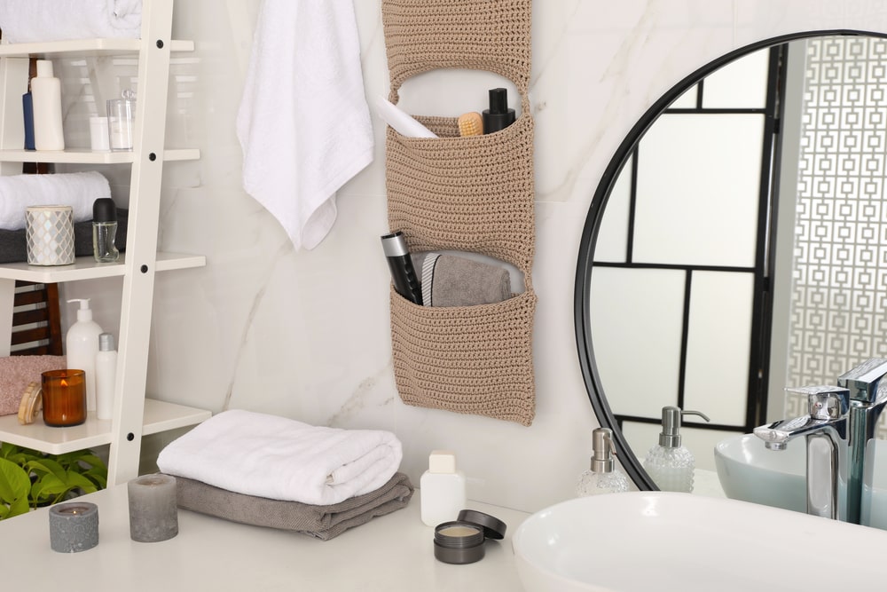 white wood shelf and fabric pocket shelf near the bathroom vanity