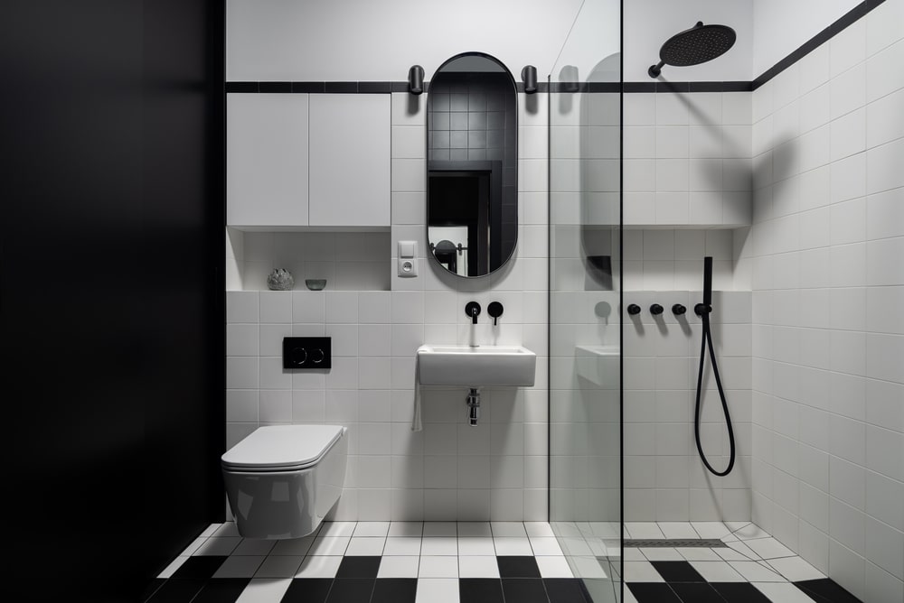 black and white bathroom with white cabinet and black faucets