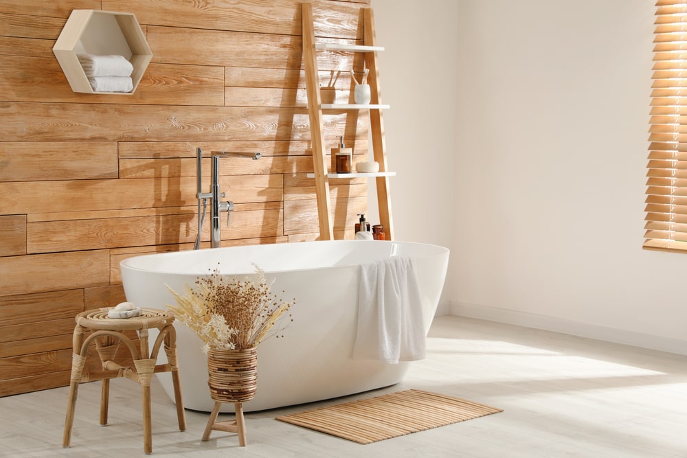 freestanding tub with ladder shelf and wooden decor in the bathroom