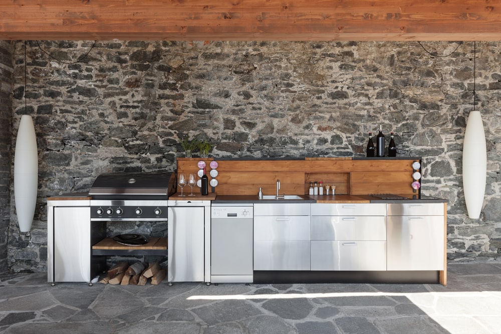 stainless steel outdoor kitchen cabinets and appliances against the wall