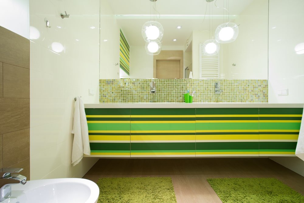 striped green vanity in the bathroom with a large mirror