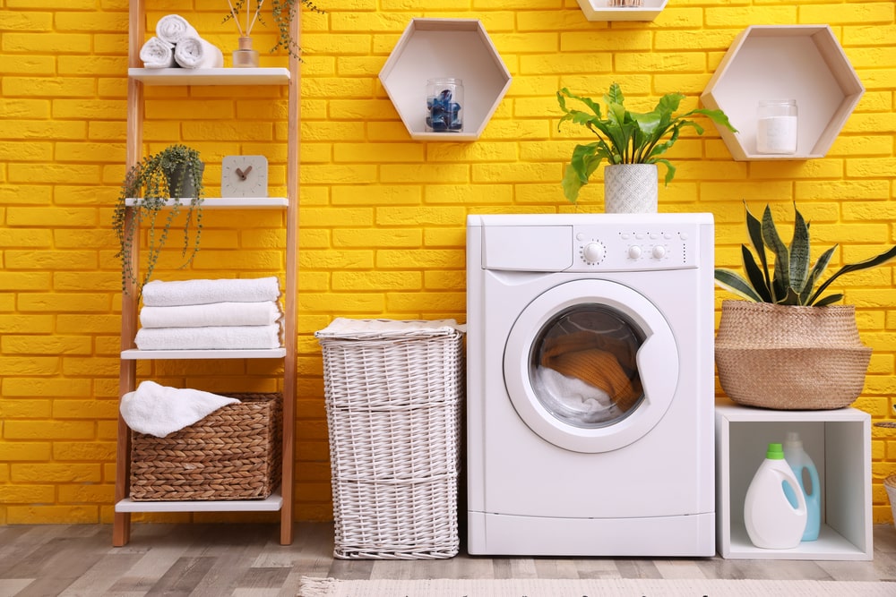 washing machine with hamper and shelves in the laundry room