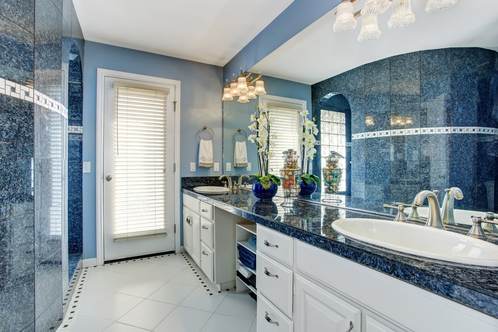 blue bathroom design with a large mirror that deepens the space