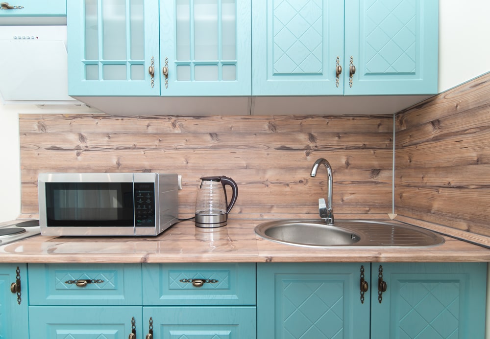 teal cabinets and wood look worktop
